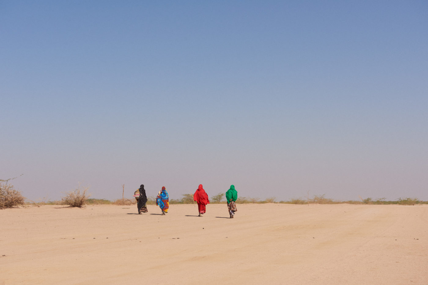 Women walking away on sand